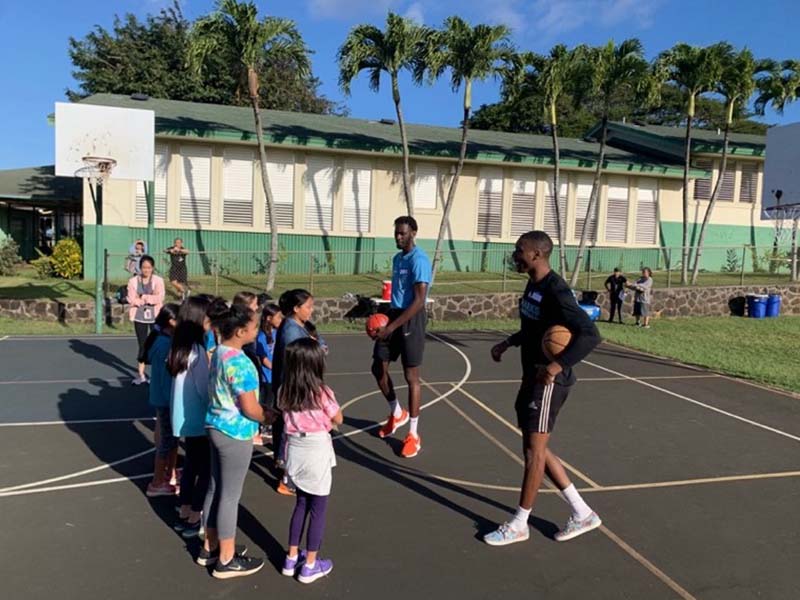 Mens Basketball players leading Maemae students in a basketball drill