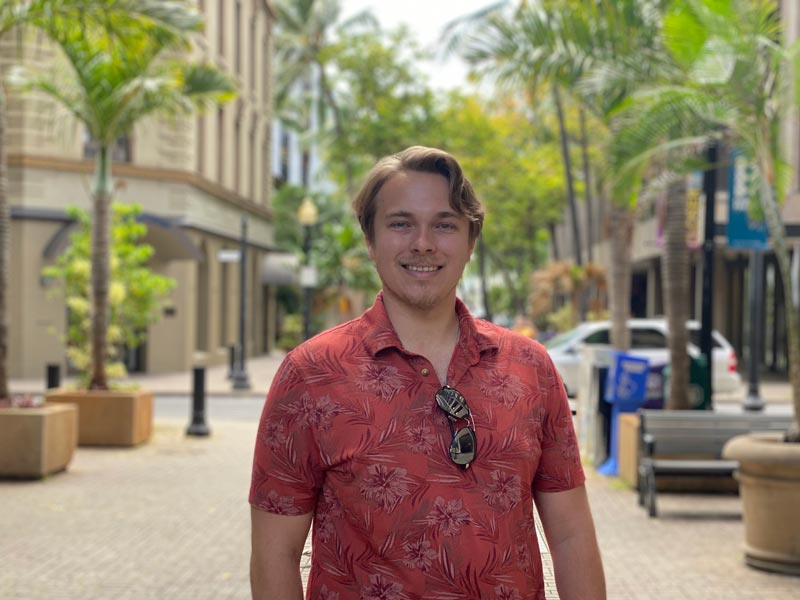 male graduate student standing outside university in hawaii