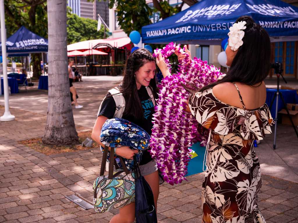 A new student receives a lei at Aloha Tower Marketplace