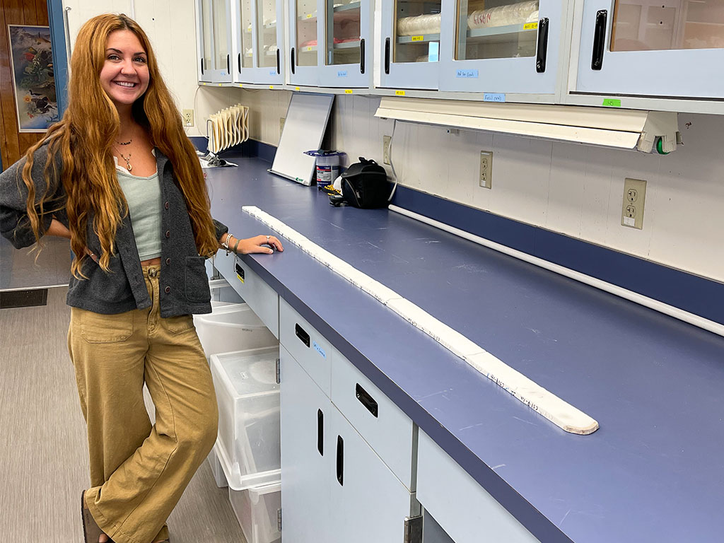 Jessica Hankins stands next to a coral core.