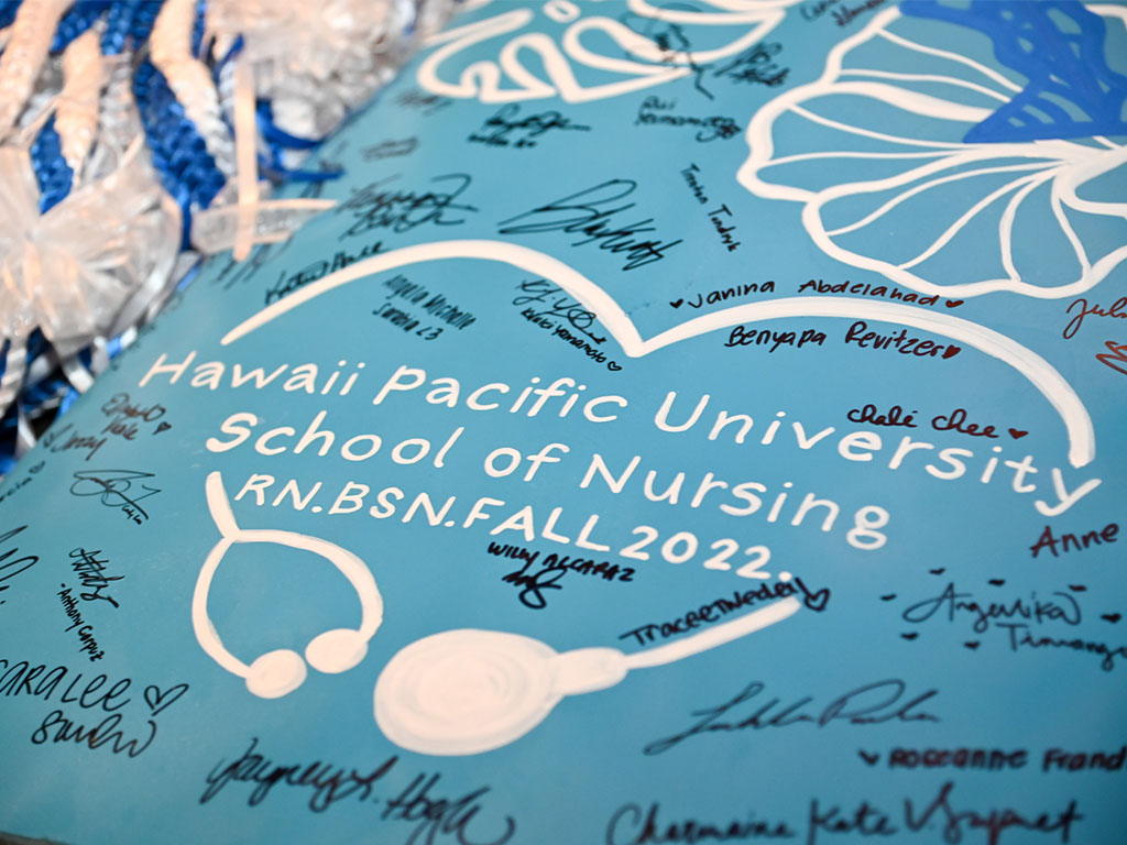 53 Bachelor of Science in Nursing graduates signed their names on a plaque