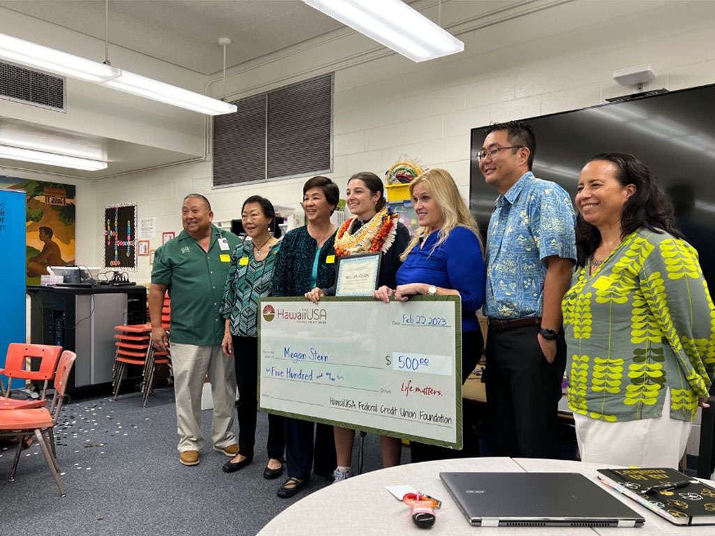 Megan Stern receives a check from HawaiiUSA Federal Credit Union