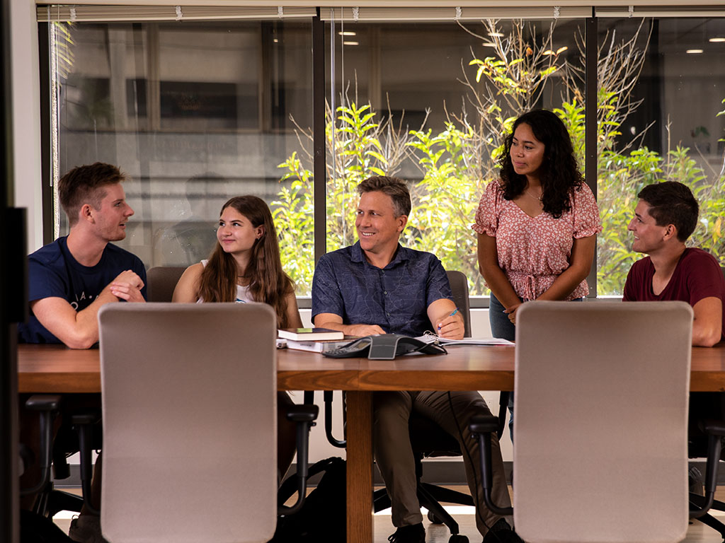 Gerard Dericks (center) with HPU students at the HPU College of Business