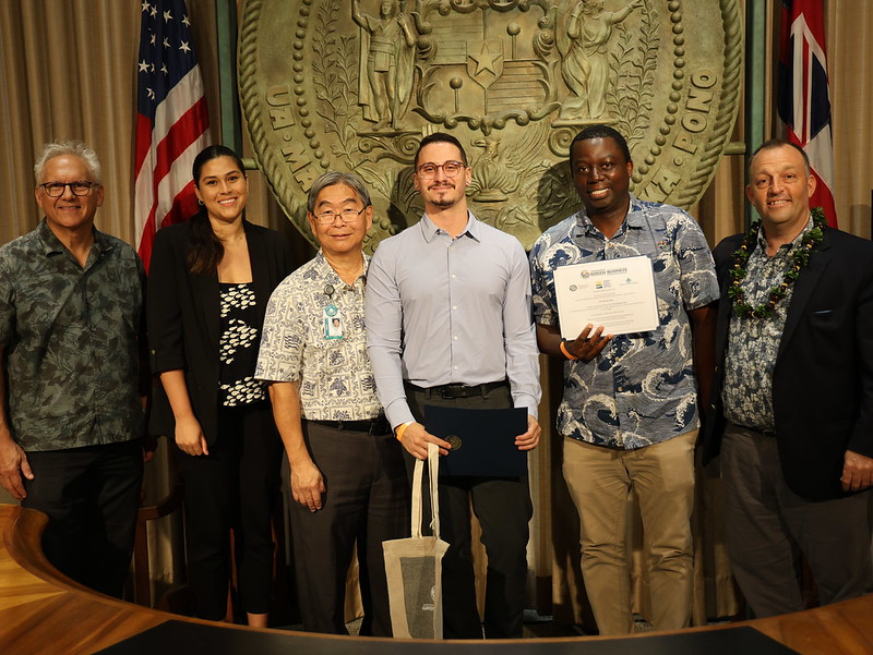 Pictured from left to right: Mark B. Glick, Hawaii State Chief Energy Officer, Irina De La Torre, Hawaii Tourism Authority Brand Manager, Ernie Lau, Honolulu Board of Water Supply Chief Engineer, Michael McKinnon, Aramark, for Pier Nine by Sam Choy Food Service Manager, Clarence Ncube, HPU Project Manager for Facilities, Sustainability, and Master Planning, and State of Hawaii Governor Josh Green, M.D. Not pictured: Dickson Alvarado, Aramark, for Pier Nine by Sam Choy Food Service Director. Photo courtesy Department of Business, Economic Development and Tourism Hawaii State Energy Office.