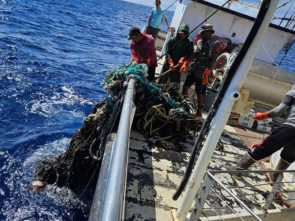 Crew, who are members of the Hawai'i Longline Association, removing a 698 pound derelict fishing gear out of the ocean while at sea. Image courtesy of Seeker II