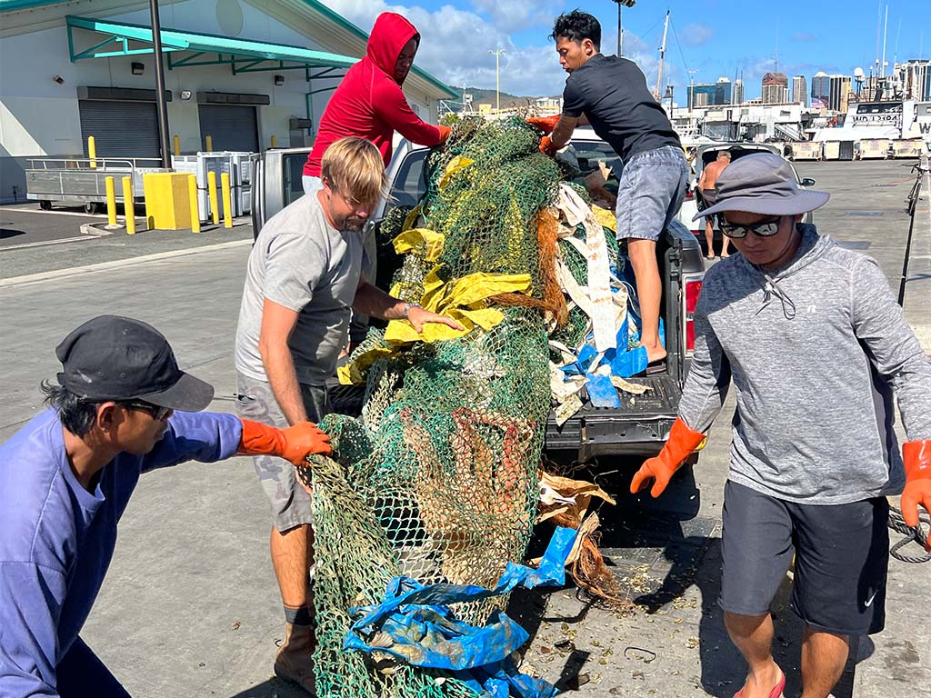 Crew, who are members of the Hawai'i Longline Association, offloading a 313 pound burrito drifting fish aggregation device (dFAD) with the help of Hank Lynch, a commercial fisherman