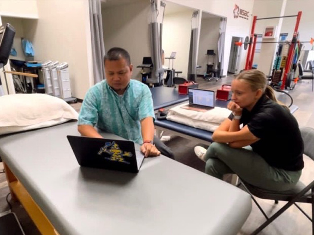 Meynard Enriquez, DPT, (left) with Class of 2024 DPT student Kennedy Schuelke in clinic