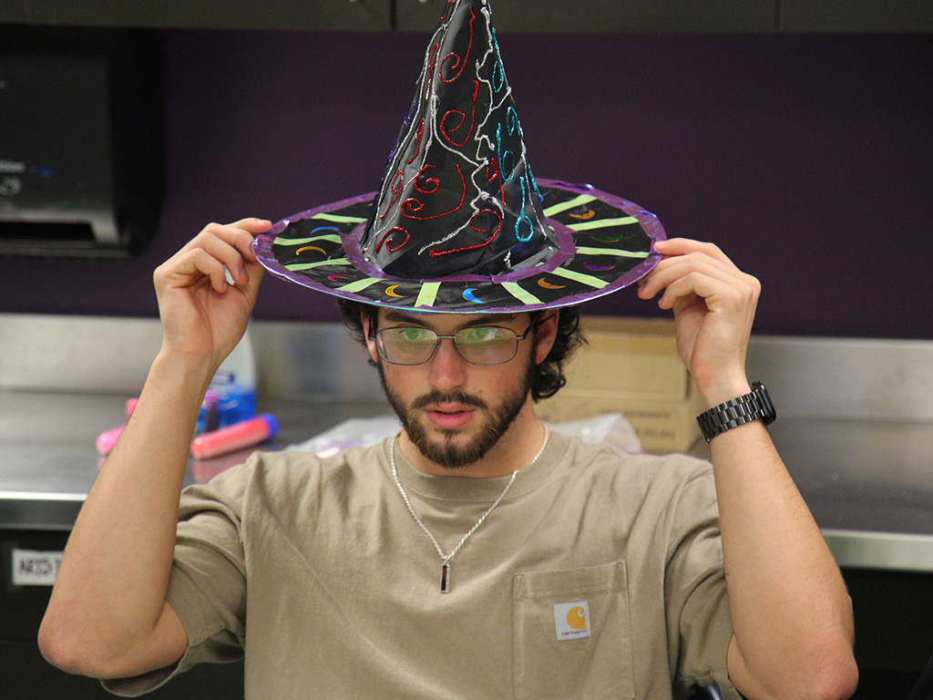 An HPU student wearing a wizard hat for the interactive session