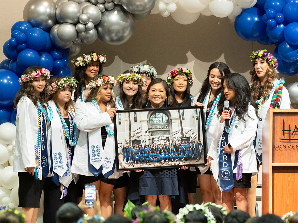 HPU Dean of the School of Nursing Edna Magpantay-Monroe (center) with fall 2023 HPU nursing graduates