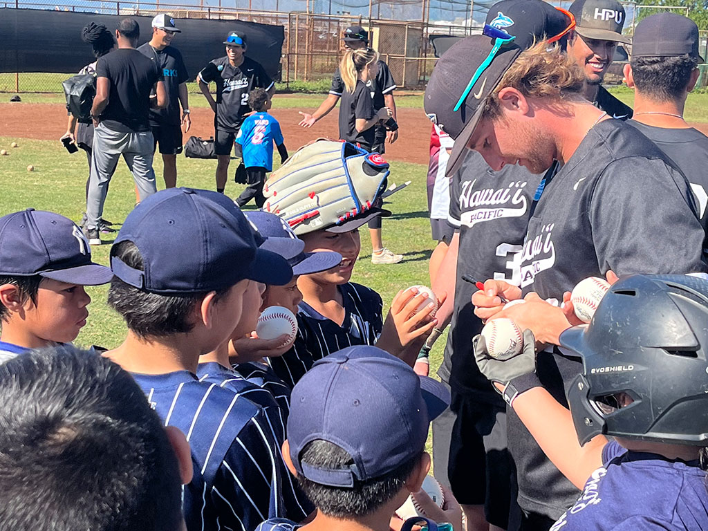 Chase Taylor signing baseballs at the HPU Youth Baseball Clinic