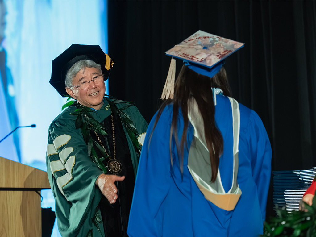 HPU President John Gotanda congratulates an HPU student upon receiving their degree