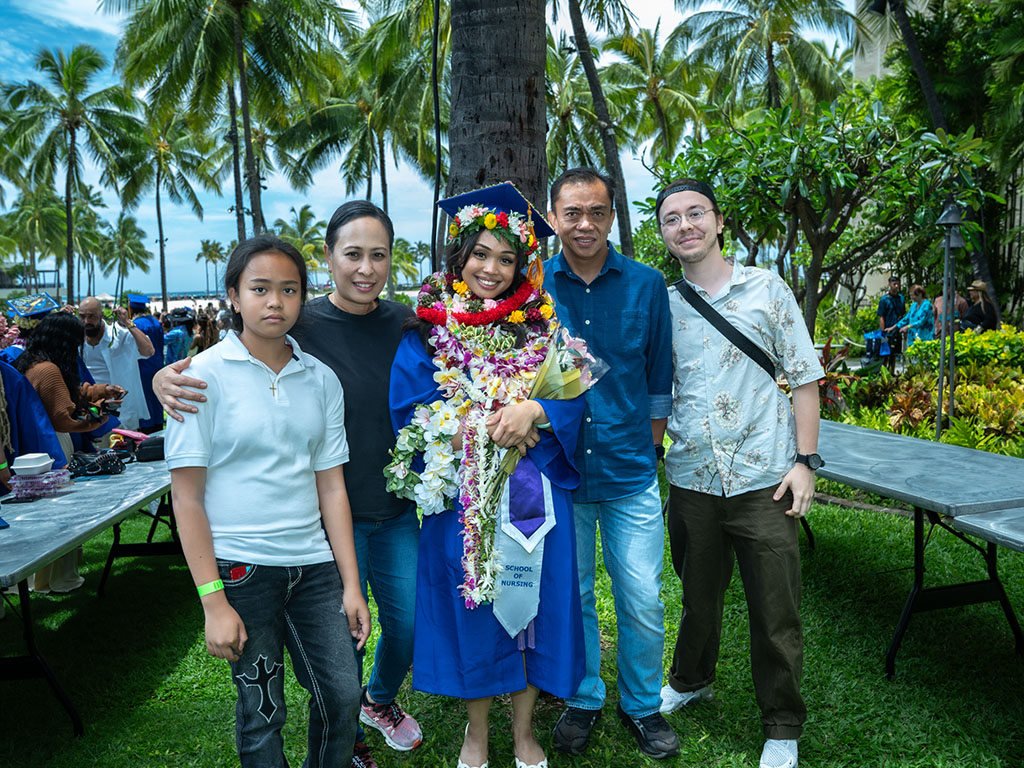 An HPU graduate and her family at the Duke Paoa Kahanamoku Lagoon, just steps away from the graduation stage