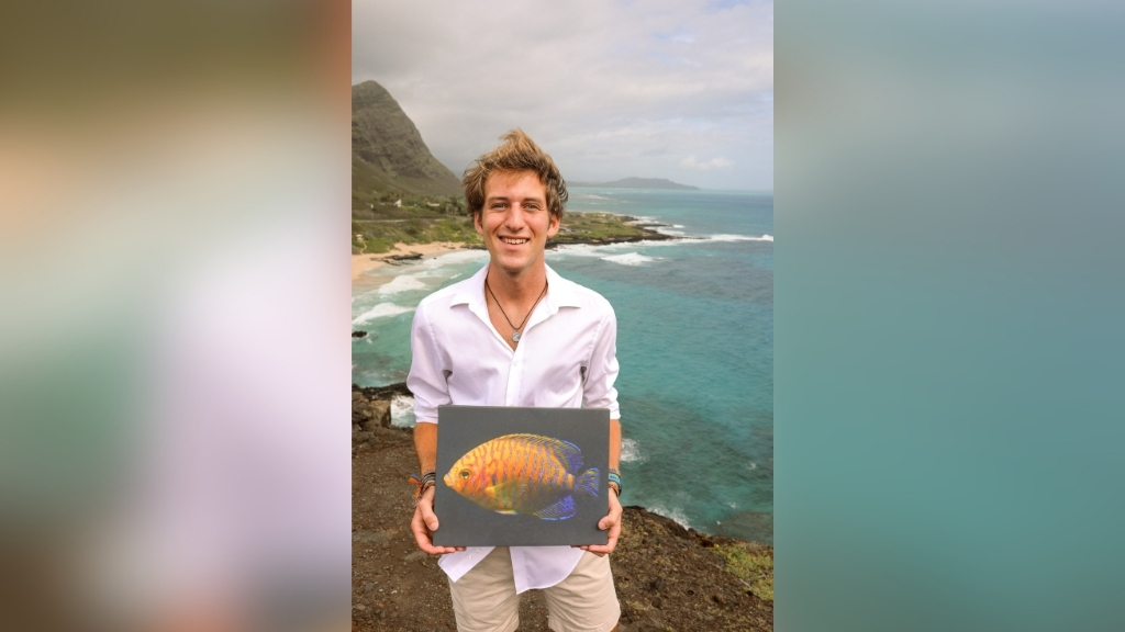 Kent Glover at Makapu'u Point holding photo print of a Potter's angelfish