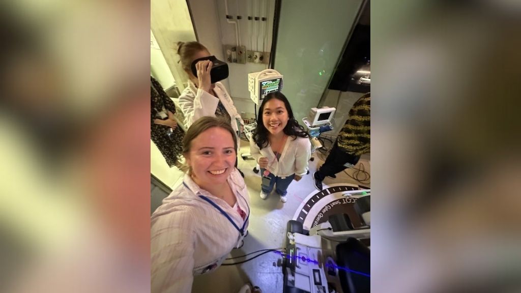 Dr. Joy Bliss wearing the virtual goggles, with students Tipp Tiensuwan and Esme Tsirkas