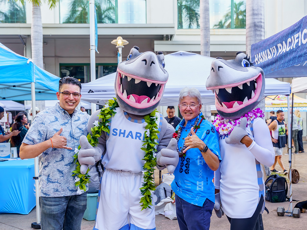 HPU President John Gotanda (second from right) with HPU Dean of the College of Professional Studies Mani Sehgal (far left) with HPU mascots Sharky and Fynn