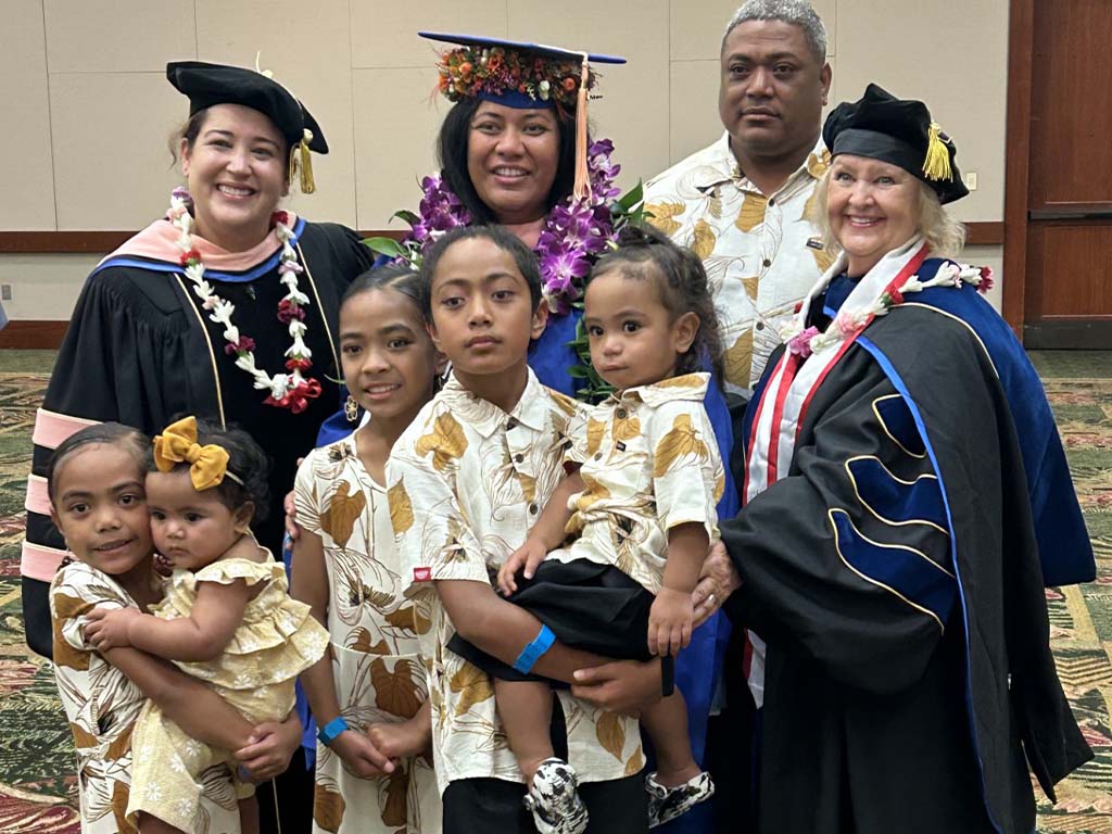 Atalina Pasi (Master of Public Health '24) celebrating with her husband and children and faculty Erika Collazo-Vargas (left), Ph.D., and Jayne Smitten, Ph.D., at HPU's December 2024 graduation ceremony