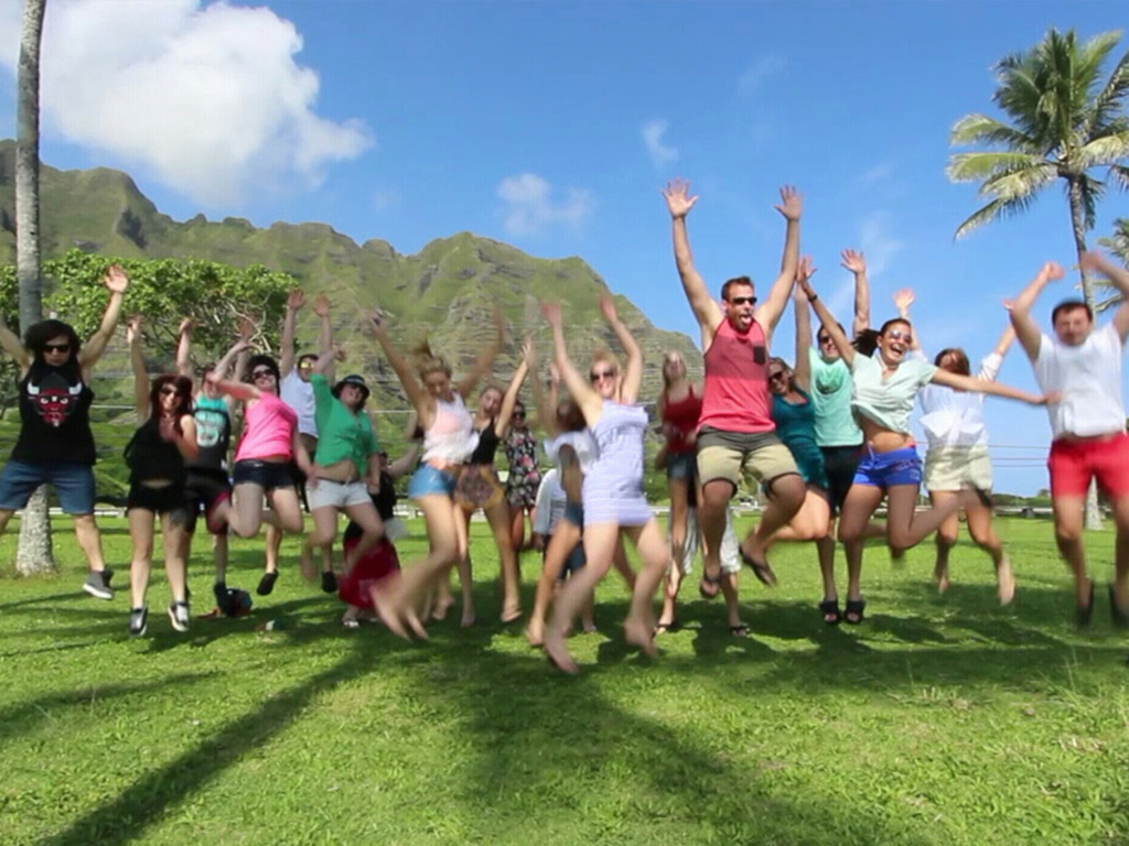 Guests on the North Shore Beach Bus jumping for joy near Kualoa Ranch, Oahu