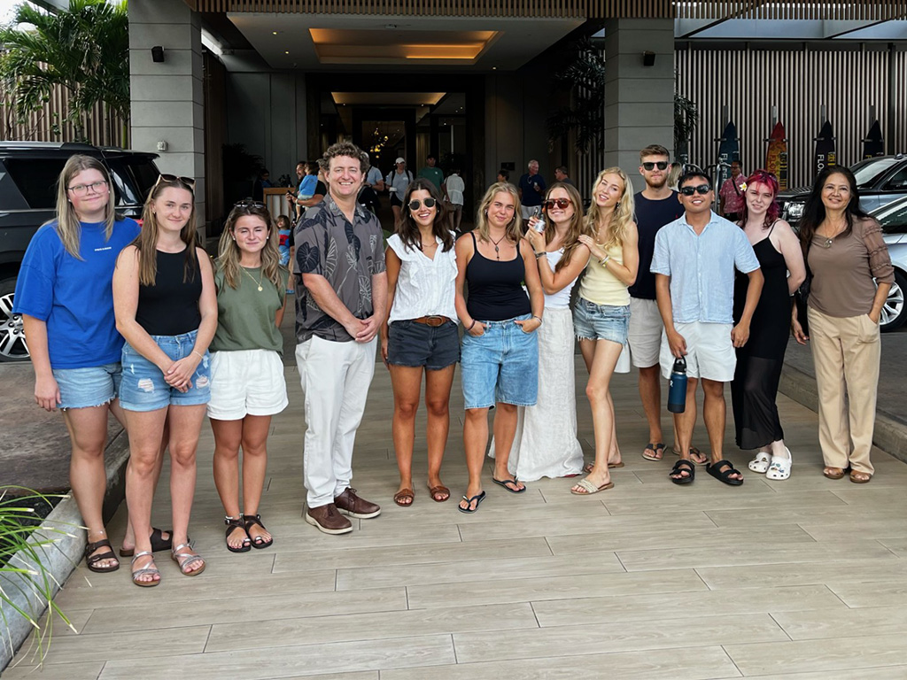 HPU College of Business students gather at the entrance of the iconic Ritz-Carlton Oahu, Turtle Bay with Joey Woofter (fourth from left) and Michelle Alarcon (far right)