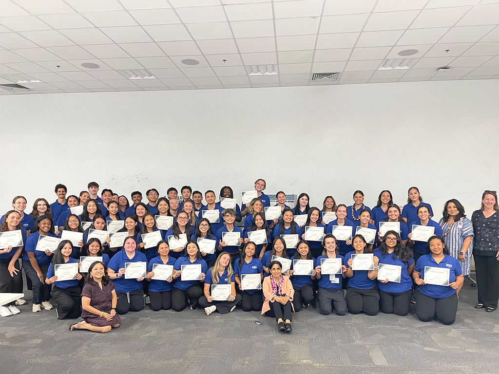 HPU senior nursing students gather during the Spring 2026 Evidence-Based Practice Showcase at Aloha Tower Marketplace. Pictured front row center is Hazel Downing; front row left is HPU Dean Edna Magpantay-Monroe; and standing second row right in stripes is keynote speaker Robin Kalohelani