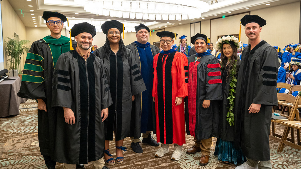 HPU PsyD graduates and faculty at Spring 2026 Commencement, held May 7, 2026. Left to right: Assistant Professor Andrew DeWald, Robert Alex Blake, Jay Lee, Assistant Professor Joseph Cice, Professor Vincent Tsushima, Assistant Professor Halleh Hastpari, Mailani Chang, Blake Harrison