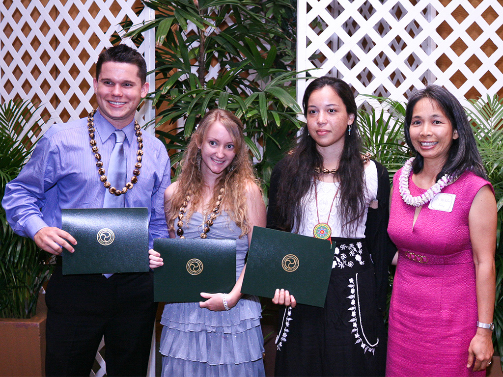Michael Bennett (left) at graduation with fellow graduates and HPU Professor Micheline Soong (far right)