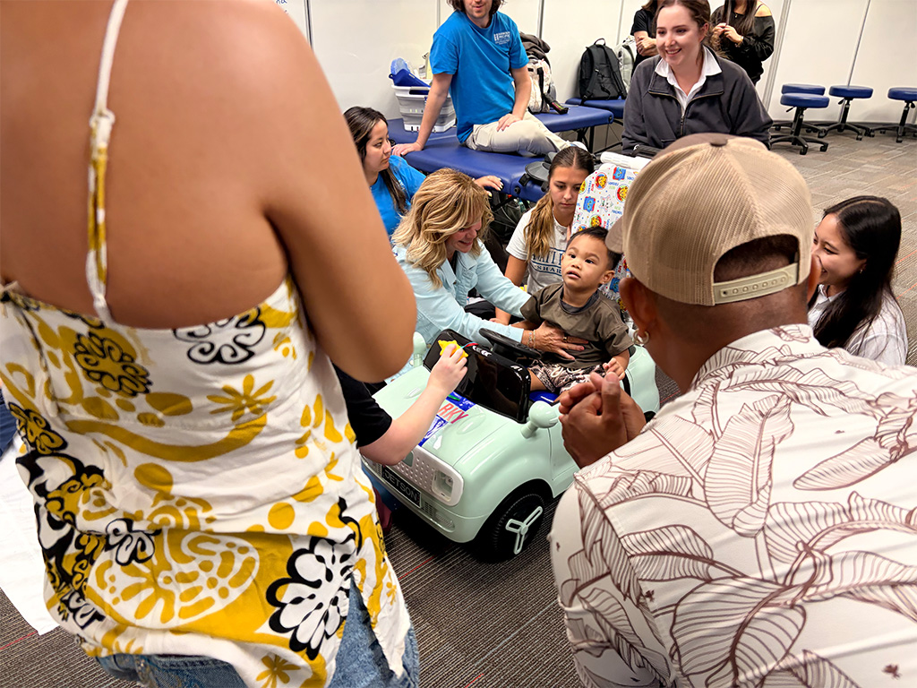 A child gets ready to press the activation switch on the car to drive around the laboratory floor