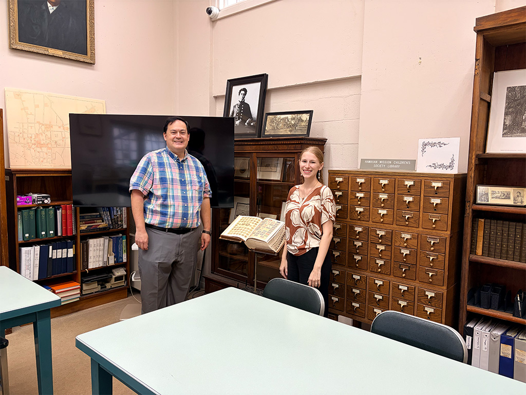Doug Askman (left) and Morgan Cassens (right) in the Hawaiian Mission Children's Society Library at the Mission Houses, where the Society's collection of books, manuscripts and photographs from Hawai'i's missionary period is kept