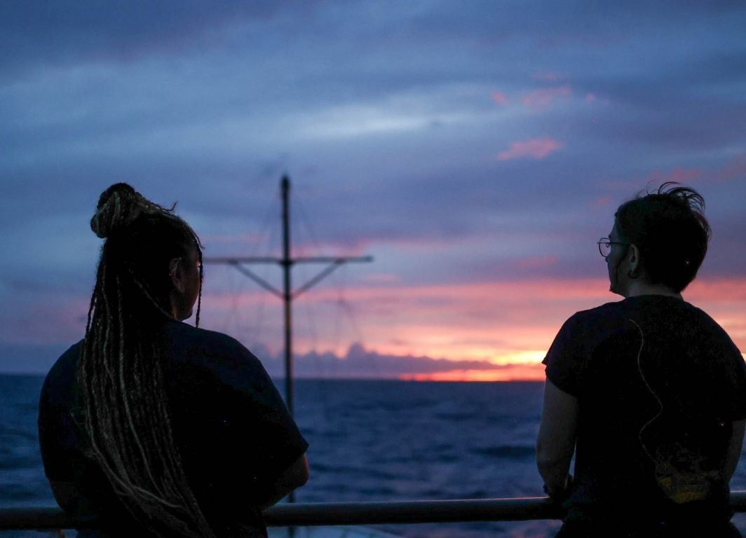 Ogbaekwe, left, and a fellow team member watch the sunset in the Pacific Ocean