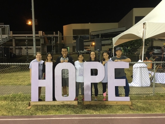 Alpha Epsilon Delta students at Relay For Life, leaning on sign that says HOPE
